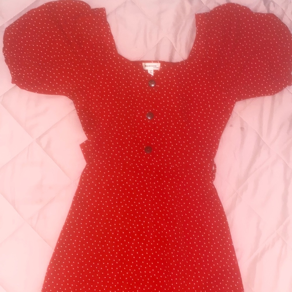 Red Polka Dot dress with puffed sleeves , buttons , and ribbon .